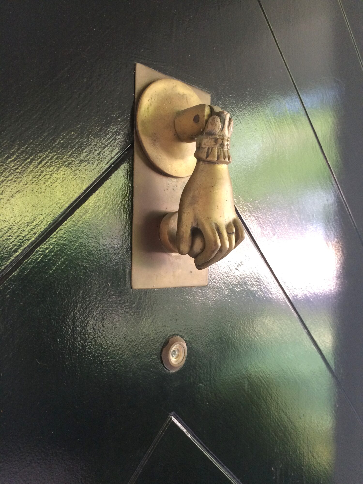 brass "hand" door knocker on exterior black door