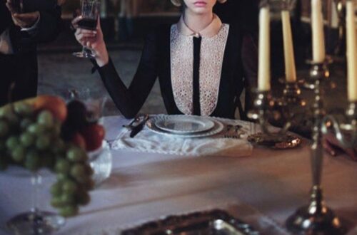 cropped W Mag cover of woman being poured a glass of wine at a formal dining table in a dark room