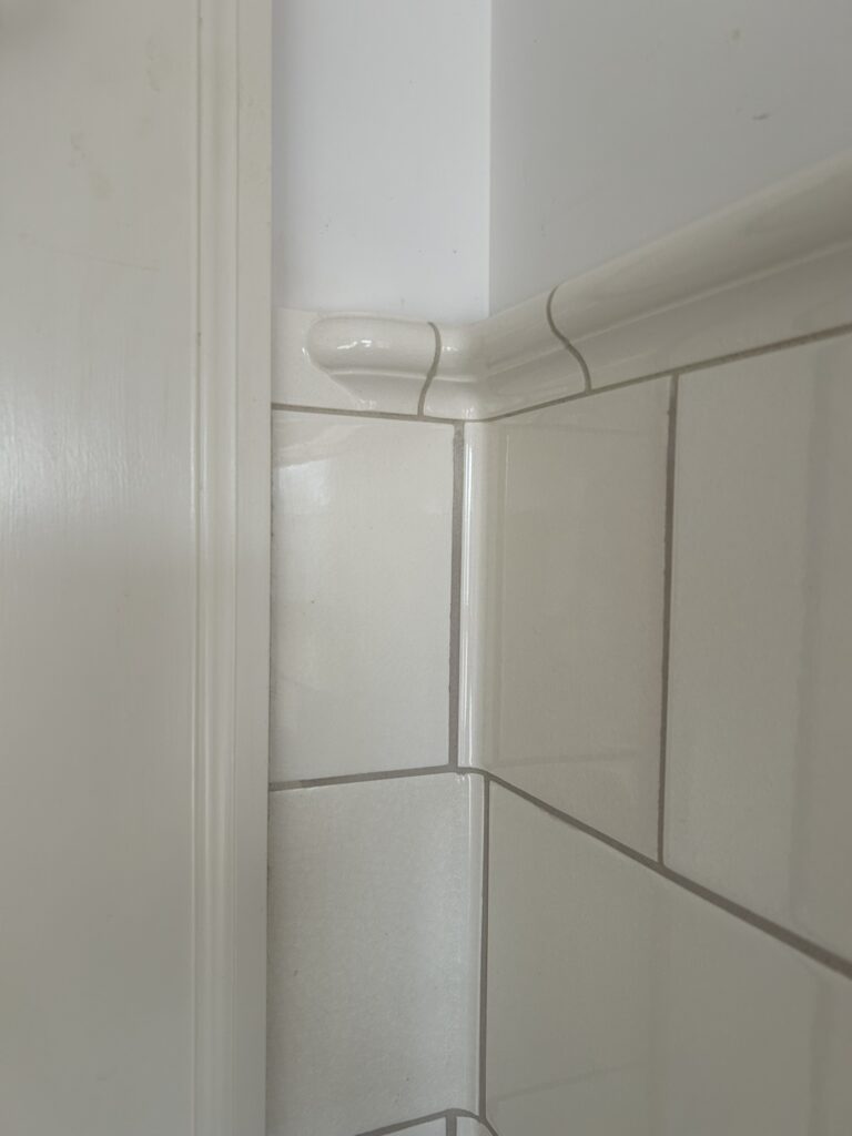 subway wall tile installed at a corner with a cap