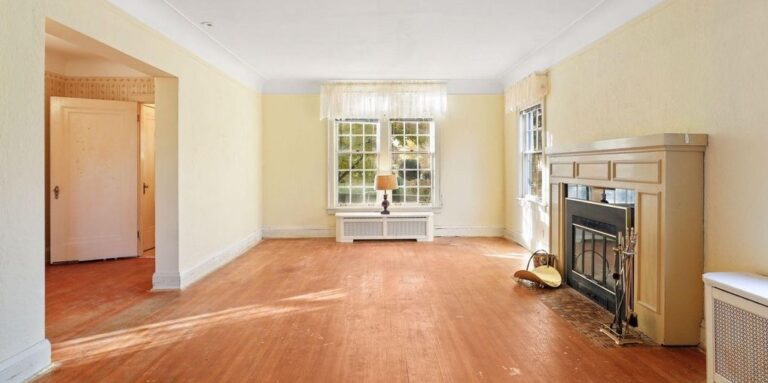 before photo of living room showing front window, fireplace and foyer staircase