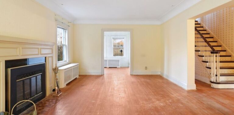 before photo of living room showing entry to den, fireplace and foyer staircase