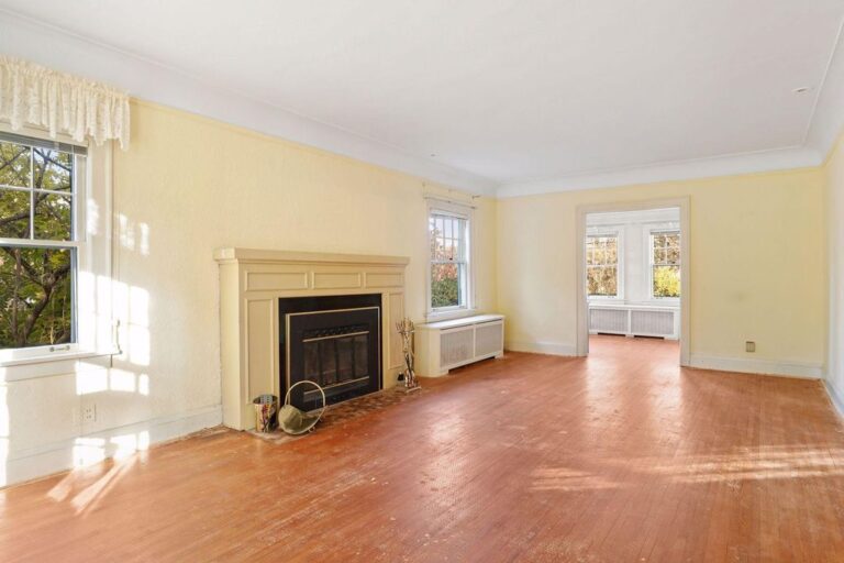 traditional living room with fireplace and wood floors in dated condition