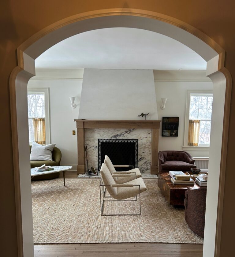 view through archway to a living room with a fireplace