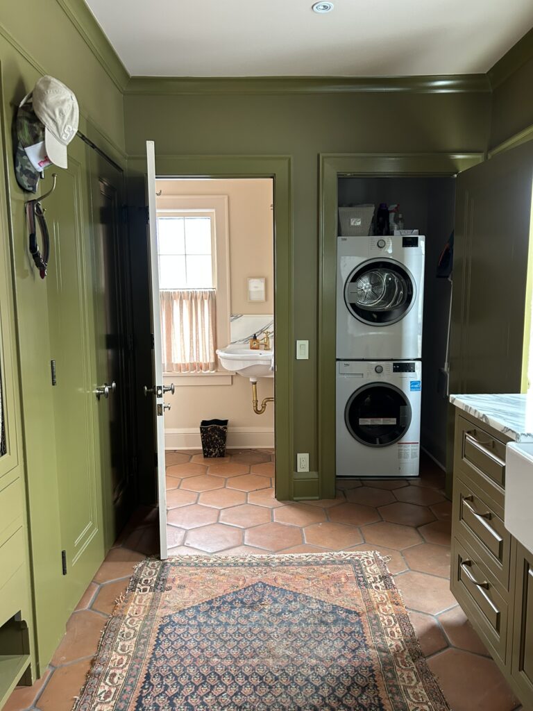 green mudroom with views into laundry and mudroom