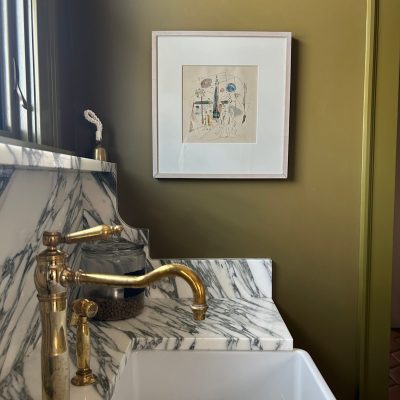 modern art on green wall above sink and marble splash in mudroom